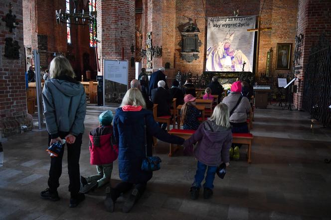 Archiwalne zdjęcia Jana Pawła II w Bazylice św. Brygidy w Gdańsku. Fotografie pojawiły się przy Grobie Pańskim