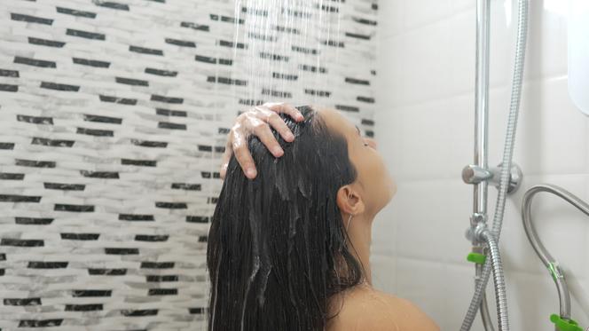 Kobieta myje włosy pod prysznicem 