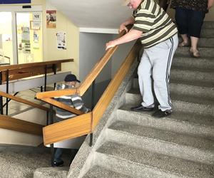 Pacjenci czołgają się po schodach
