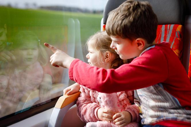 Dzieci w pociągu wygladające przez okno
