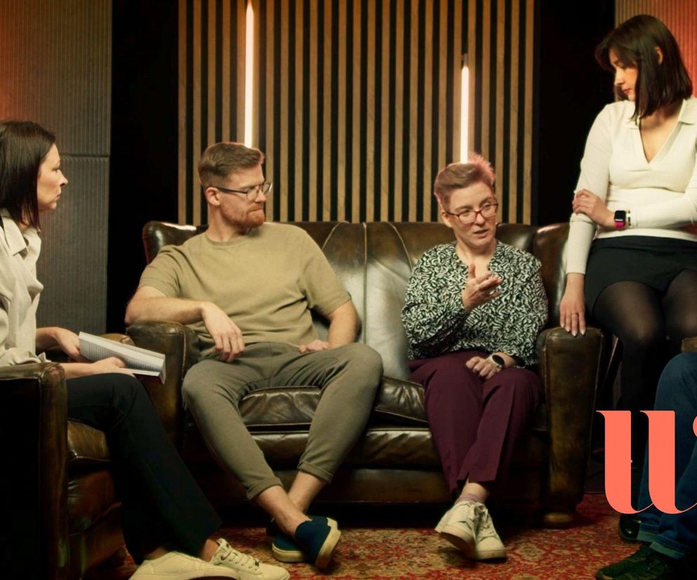 Grupa osób siedzi w pomieszczeniu o panelowych ścianach, rozmawiając o zaangażowaniu pracowników, które buduje szacunek, sens i uczciwe zasady. Konferencja Wrocław Wellness, poruszająca kwestie zdrowia fizycznego i psychicznego w pracy, jest tematem, o którym można przeczytać na portalu Poradnik Zdrowie.