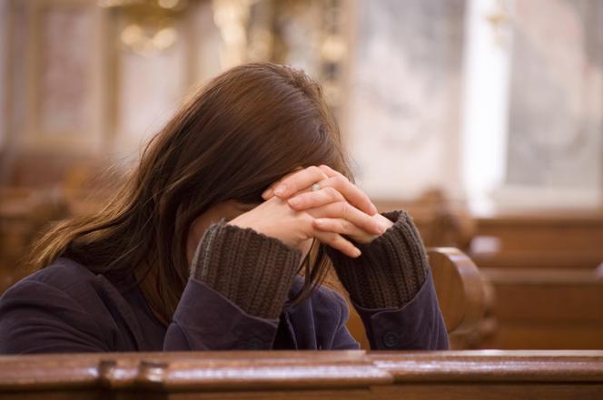 Zbliżenie na młodą kobietę, która się modli 