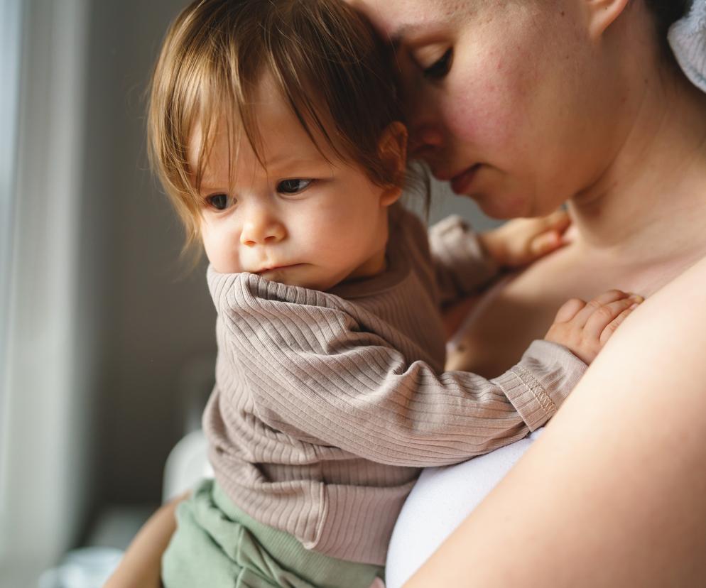 Smutna mama z dzieckiem na rękach