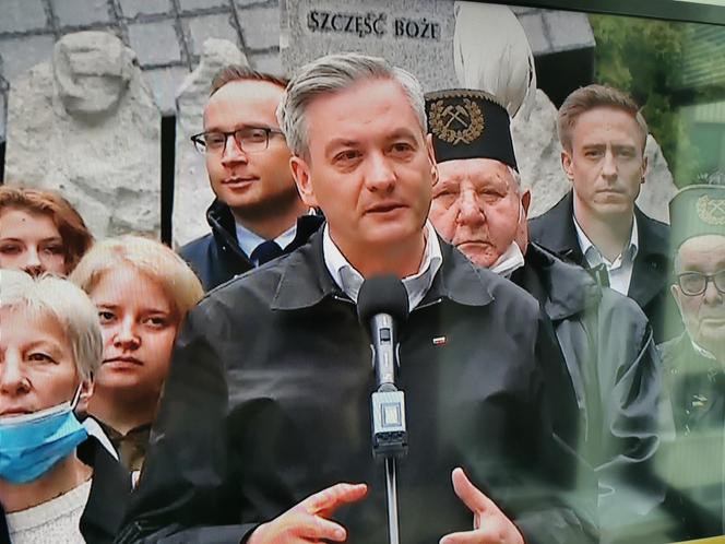 Robert Biedroń na tle religijnego hasła