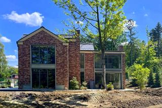 Dom z elewacją z czerwonej cegły i wielkimi oknami