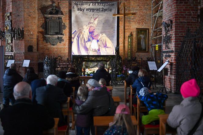 Archiwalne zdjęcia Jana Pawła II w Bazylice św. Brygidy w Gdańsku. Fotografie pojawiły się przy Grobie Pańskim