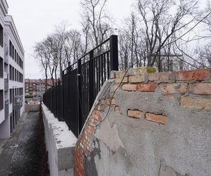 Blok z widokiem na betonowy mur. To prestiżowa inwestycja w Białymstoku