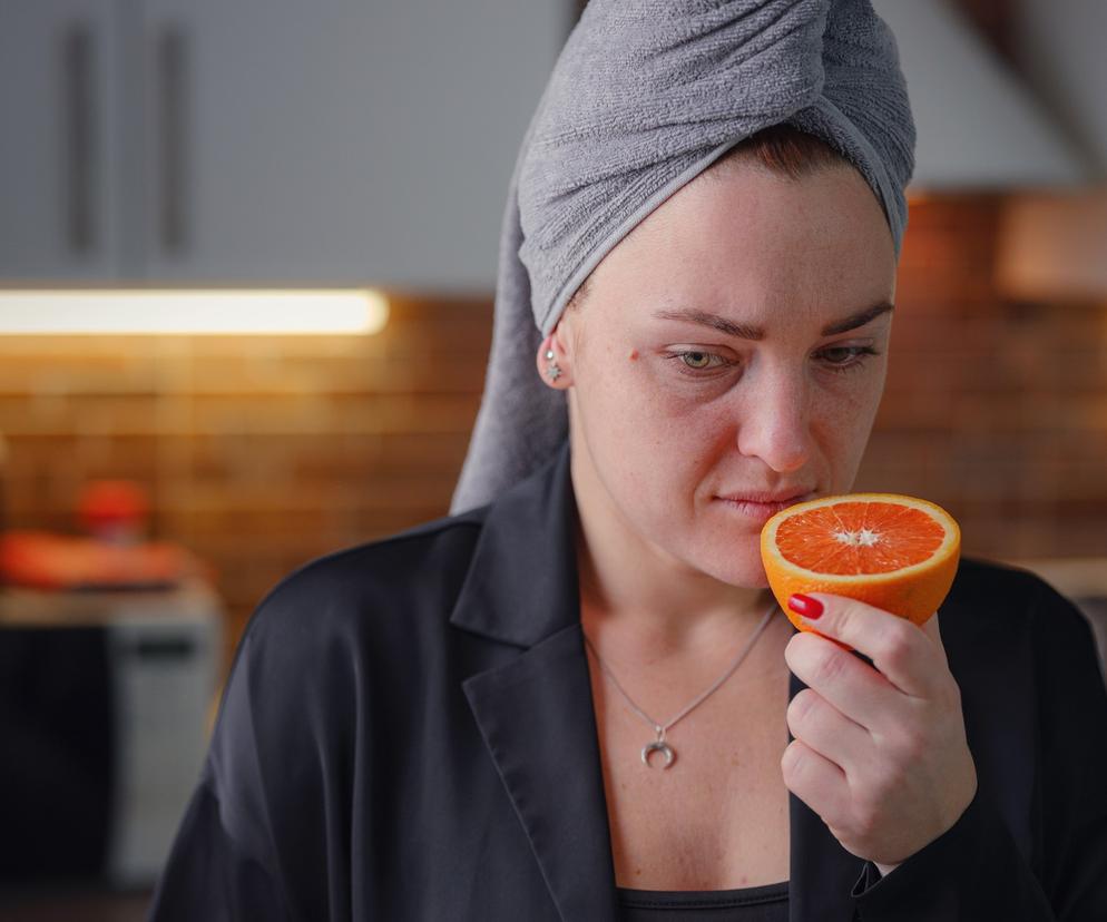 Zbliżenie na kobietę, która wącha pomarańczę