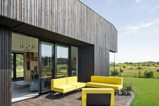 Dom z ciemnym, postarzanym drewnem z modrzewia na elewacji