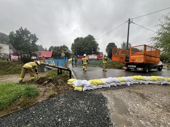 Przekroczone stany alarmowe na kilku rzekach, strażacy układają worki z piaskiem. Relacja live