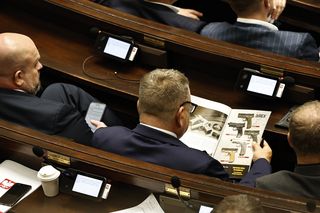 W  czasie obrad Sejmu poseł przeglądał katalog z bronią