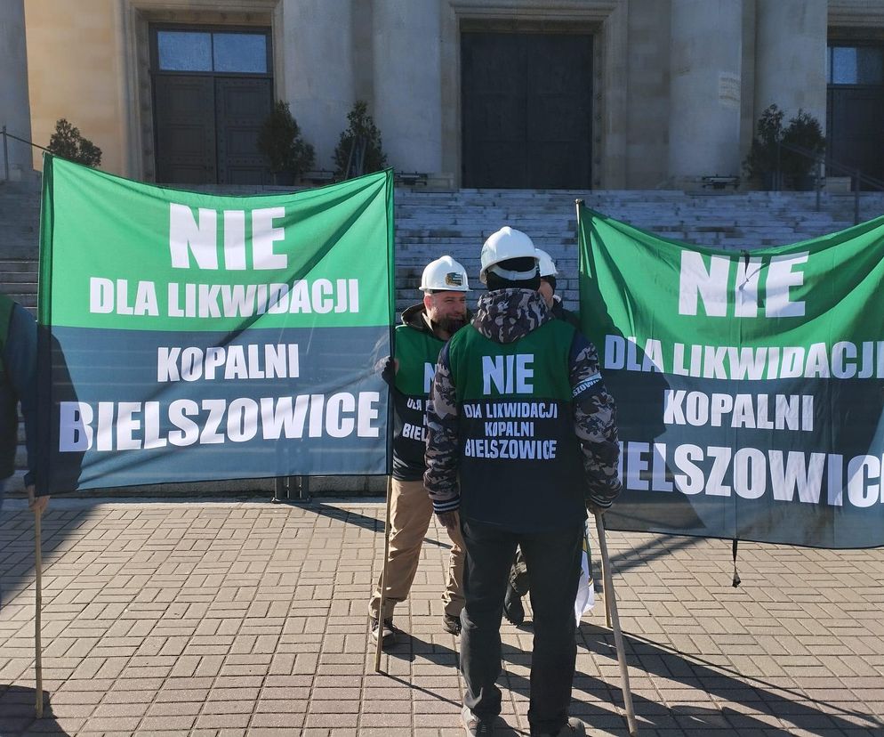 Grupa górników w białych kaskach protestuje z transparentami NIE DLA LIKWIDACJI KOPALNI BIELSZOWICE przed budynkiem w Katowicach, nawiązując do debaty Sejmu nad ustawą o górnictwie, o czym więcej na Super Biznes.