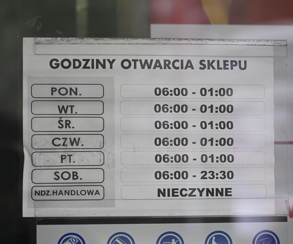 Tablica z godzinami otwarcia sklepu, wskazująca, że obiekt jest nieczynny w niedziele handlowe. Od poniedziałku do piątku sklep działa w godzinach 6:00-1:00, w soboty 6:00-23:30. To ważna informacja o zasadach handlu w niedziele dla czytelników Super Biznes.