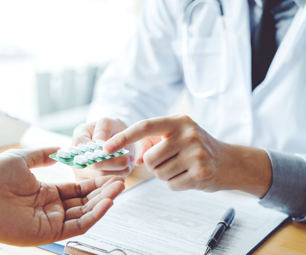 zbliżenie jak lekarz podaje pacjentowi hormony steroidowe w tabletkach - sterydy