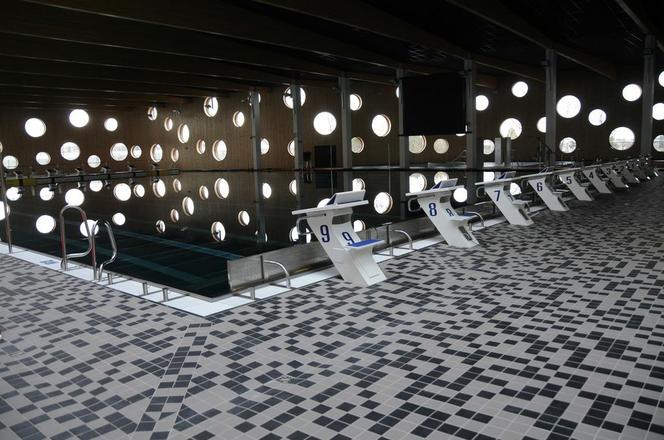 Wnętrze nowej pływalni w opolu - liczne okrągłe okna, mozaika szarych płytek na podłodze