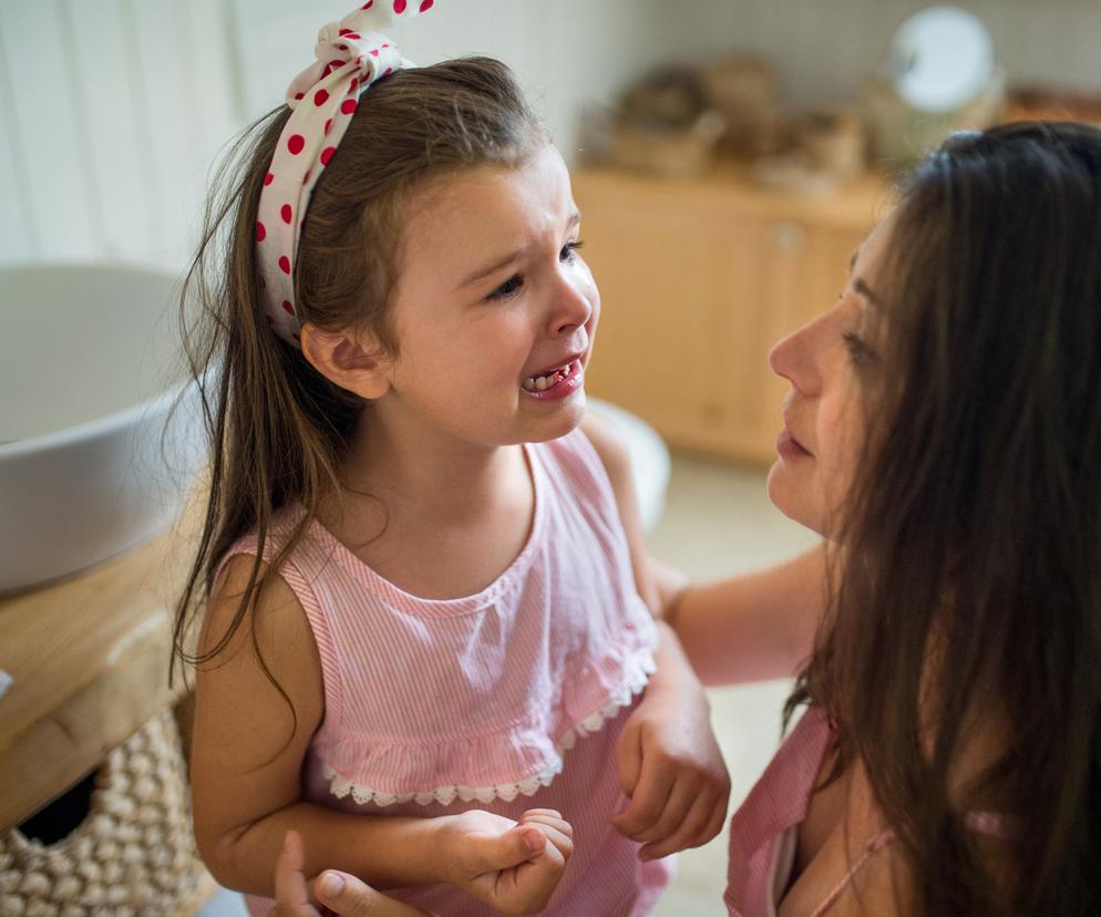 mama pochylająca się nad płaczącą dziewczynką