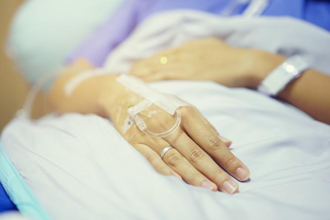 zbliżenie na dłonie kobiety leżącej w szpitalu