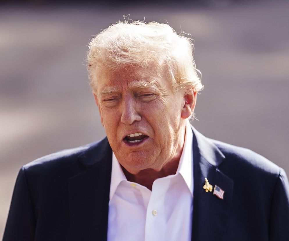 Donald Trump z zamkniętymi oczami i otwartymi ustami, ubrany w granatową marynarkę i białą koszulę, z przypiętą do klapy flagą USA. Scena odnosi się do teorii spiskowej o leczniczych łóżkach, o której więcej dowiesz się na Poradnik Zdrowie.