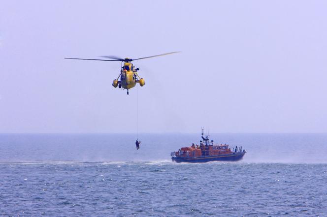 helikopter ratowniczy na morzu wyławia z wody człowieka