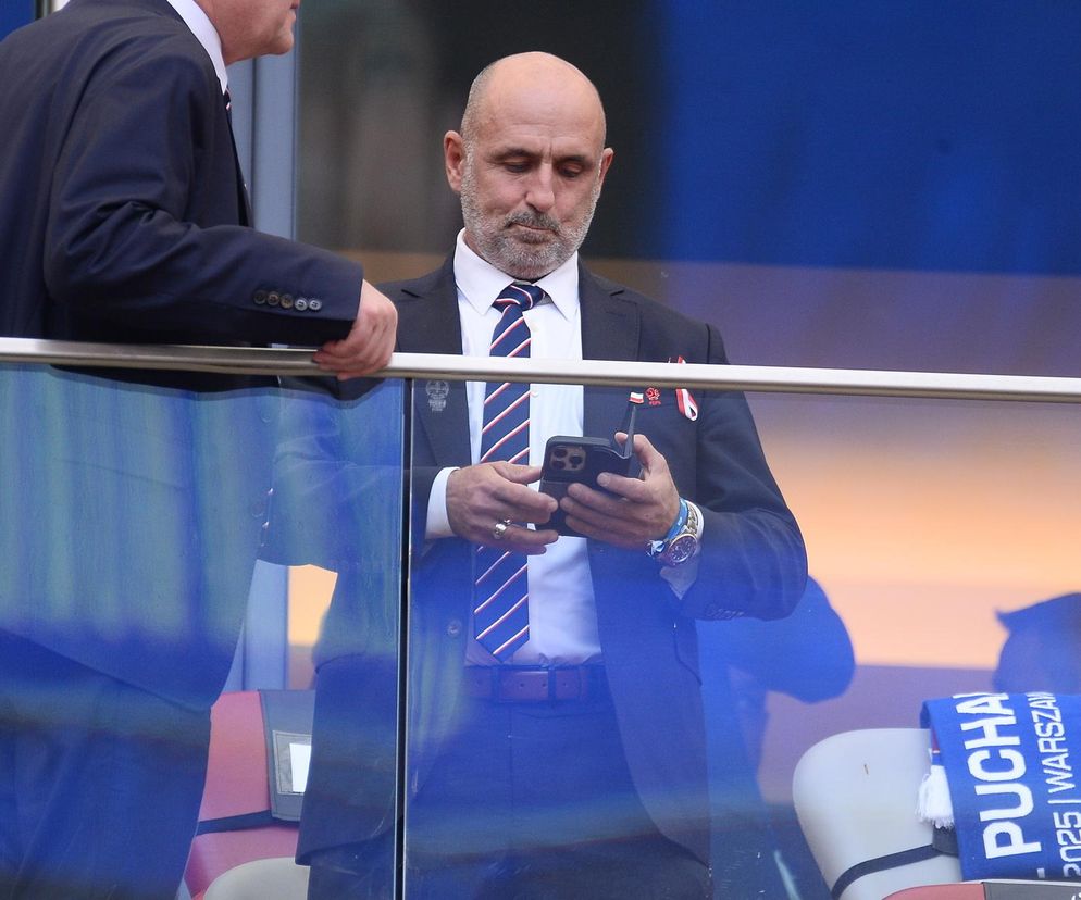Michał Probierz w garniturze patrzy w telefon. O jego ostrych odpowiedziach dla internautów przeczytasz na SE.