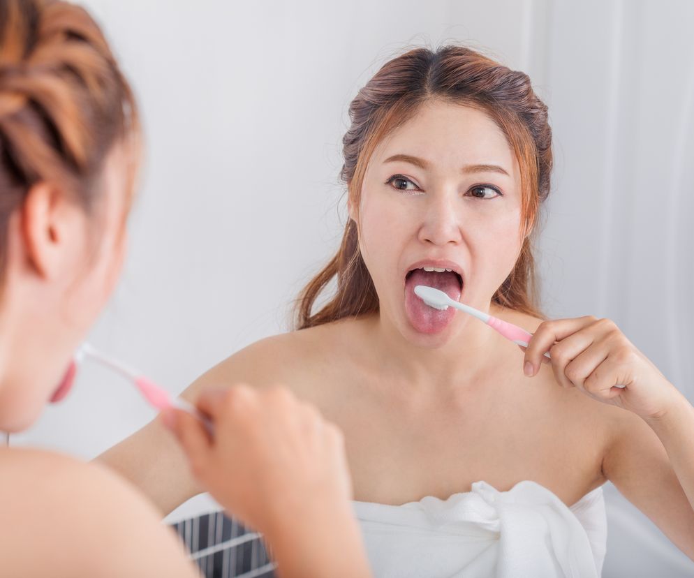 Kobieta myje język szczoteczką