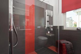 Aranżacja nowoczesnej łazienki w odważnych kolorach. Oryginalne połączenie szarości z czerwienią