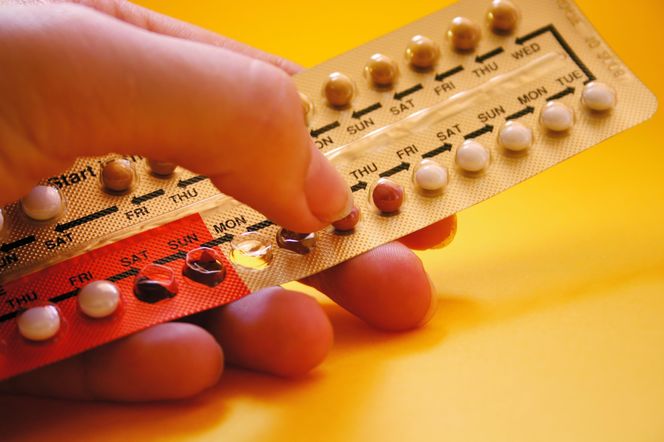 Kobieta trzyma pigułki antykoncepcyjne. Blister z lekami