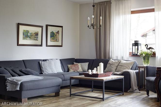 Szara sofa i szare ściany w rustykalnym salonie