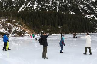 Tatry, 26.12.2022. Turyści na tafli lodu na jeziorze Morskie Oko w Tatrach
