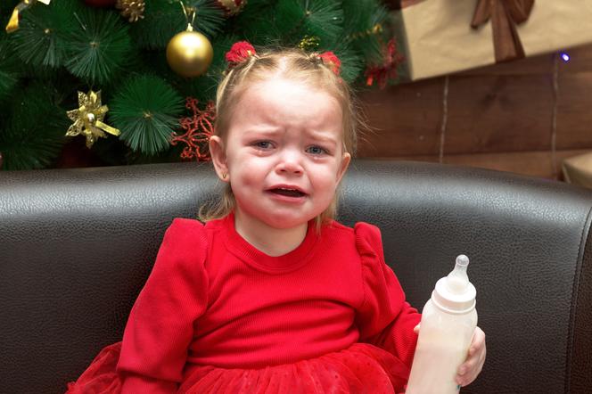 Płacząca dziewczynka przy choince