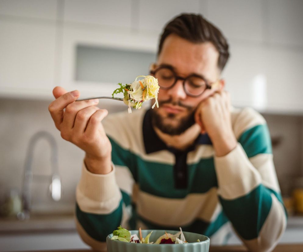 Mężczyzna jedzący ze smutkiem