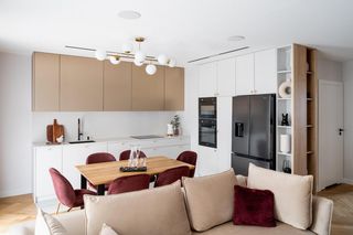 Biało-złota kuchnia i bordowe dodatki. Mieszkanie konkretne i doprecyzowane w najmniejszym szczególe