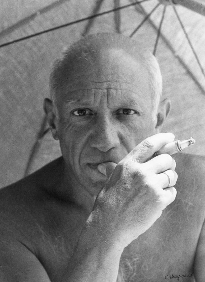 Pablo Picasso na plaży pod parasole z nieodłączną fifką w dłoni, lata 30., Francja. 