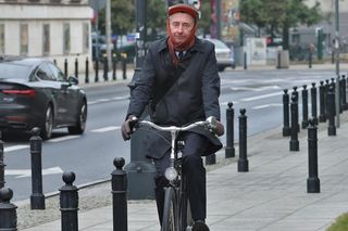 Maciej Gdula na rowerze. Chroni uszy przed chłodem