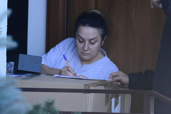 Przybita Danuta Martyniuk bez makijażu odbiera przesyłkę od synowej
