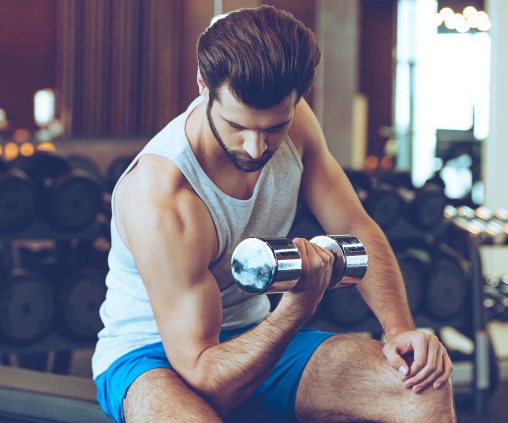 Jedno z najskuteczniejszych ćwiczeń na biceps to uginanie hantli w oparciu o kolano.
