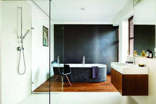 Pokój kąpielowy w stylu japandi. Łazienka z kamienną mozaiką i drewnianą podłogą
