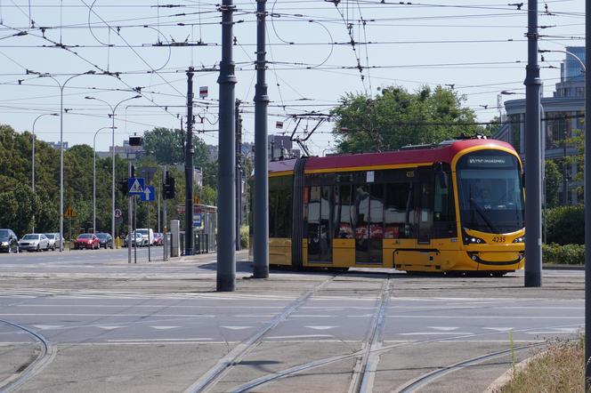 Na zdjęciu widoczny jest skręcający tramwaj linii 18. Jedzie on jednak w przeciwnym kierunku niż w tyłówce serialu