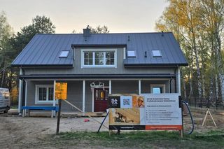 Prefabrykowany dom w Warszawie już z drewnianą okładziną ścian - trwają prace wykończeniowe