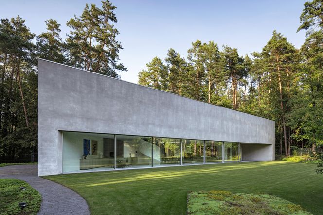 1 | Długa, horyzontalna elewacja z mikrocementu z pasem wielkoformatowych przeszkleń oraz wpuszczonym w głąb bryły tarasem