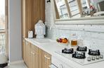 Salon w kuchni czy kuchnia w salonie? Szorstka elegancja na 40 m²