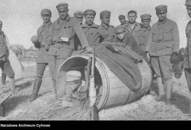 Mały chłopiec w beczce. Obok stoją legioniści I Brygady Legionów