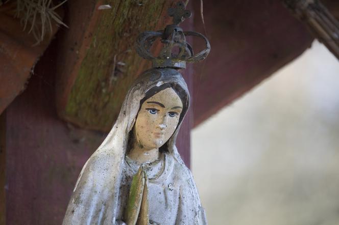 Rozbite figury Matki Boskiej i zdewastowany krzyż.