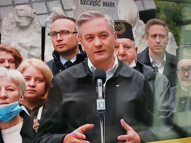 Robert Biedroń na tle religijnego hasła