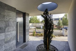 Strefa wejścia. Zadaszenie z otworem dla cisa to oryginalne rozwiązanie, które urozmaica wejście do domu umieszczone na styku części ze stromym dachem i płaskim