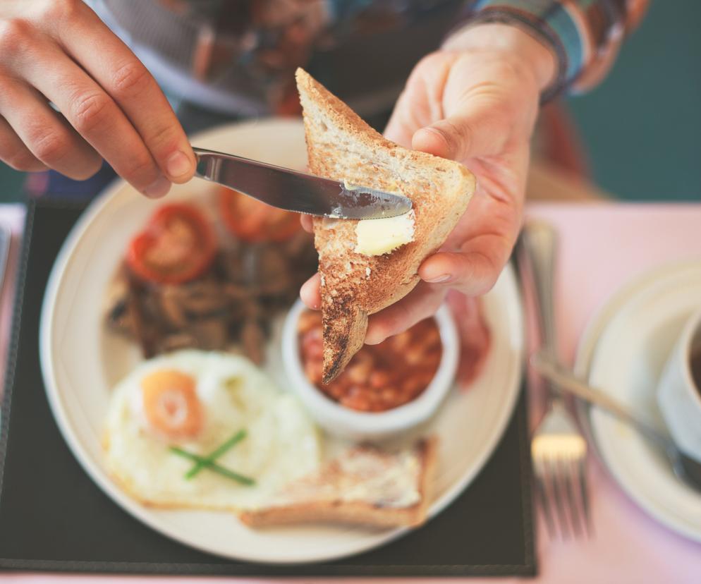 Mężczyzna smaruje tost masłem