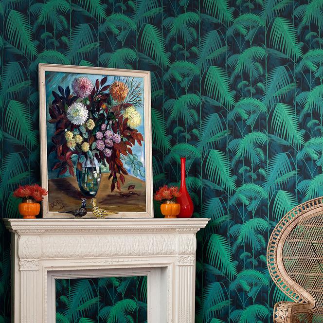 Modna tapeta z wzorem w palmy na ścianie kominkowej w salonie