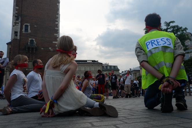 Protest na krakowskim Rynku miał formę przedstawienia - osoby grające artystów i dziennikarzy zostały skrępowane i zakneblowane