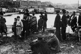 Grupa przechodniów obserwująca przypływ wody (1925)