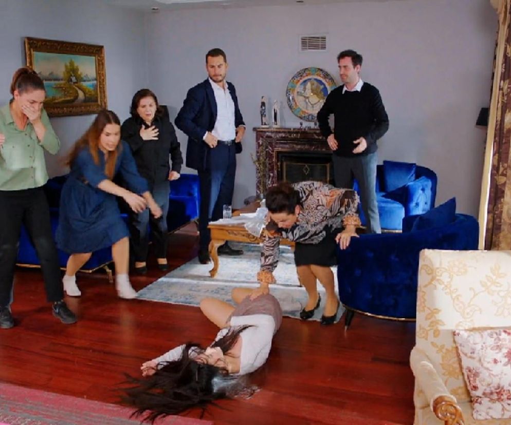 Kobieta w brązowej bluzce leży nieprzytomna na podłodze, podczas gdy inni bohaterowie serialu Miłość i nadzieja, w tym Bahar i Kuzey, patrzą na nią z przerażeniem. Scena oddaje dramatyczny moment z odcinka 301. Więcej na Super Seriale.